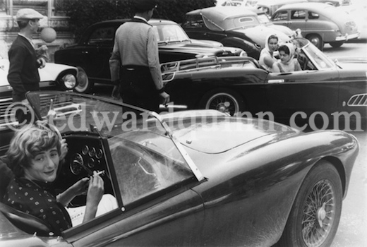 Françoise Sagan de copiloto en un AC Ace, mientras observan a la princesa Gabriela de Italia y su hermana María Pía aparcar su Ferrari 250 GT Pininfarina Series 1 - Foto: www.edwardquinn.com